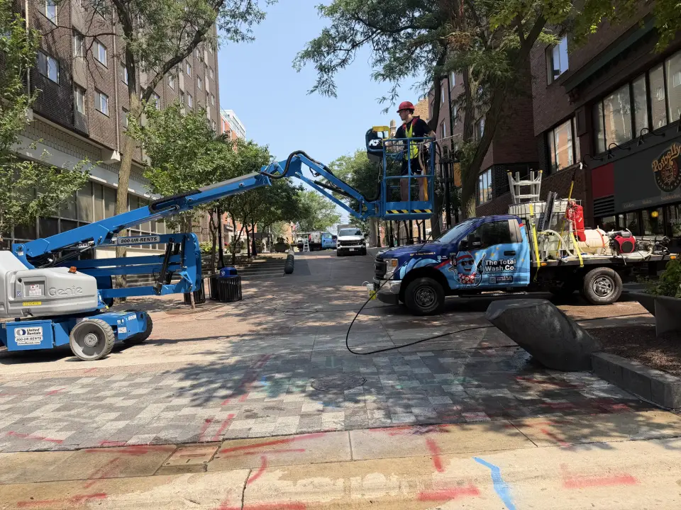 A Total Wash Co. technician on a lift preparing to clean a commercial building