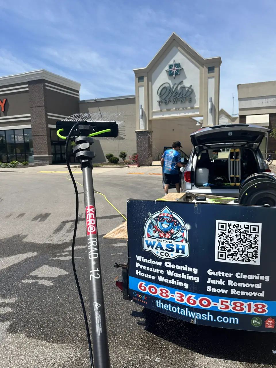 A XERO pure-water pole beside the open Total Wash Co. equipment trailer at a Madison shopping-center job