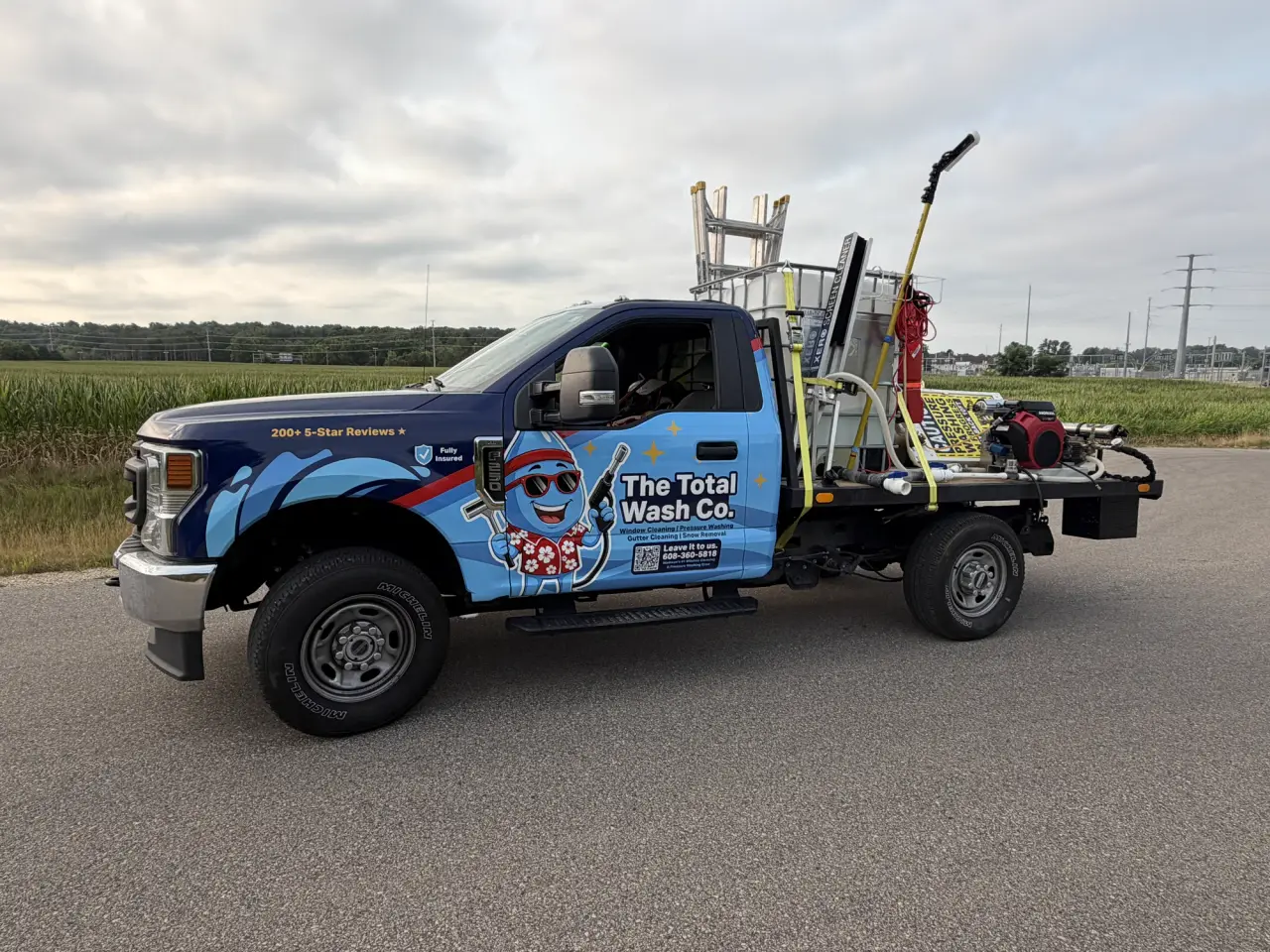 The Total Wash Co.'s wrapped Ford F-250 with the pressure-washing rig, tank and hose reels on its flatbed deck — Madison, WI