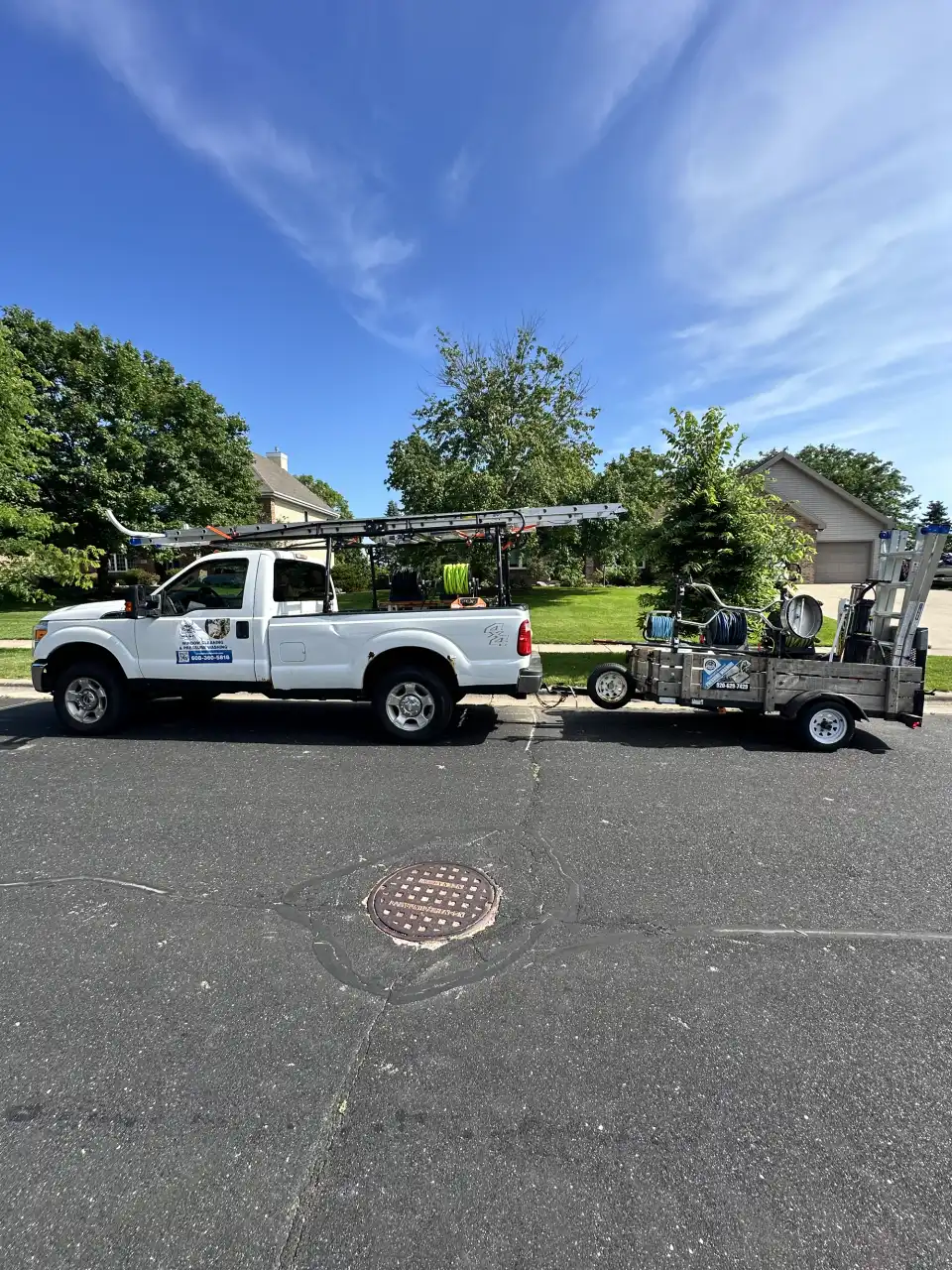 A Total Wash Co. truck and equipment trailer parked on a residential Madison-area street